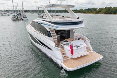 Luxury 2025 Princess F58 yacht cruising on a serene waterway.