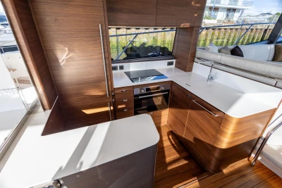 Luxurious kitchen interior of 2025 Princess F58 yacht with modern wood cabinetry and sleek design.