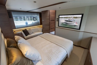 Luxurious bedroom interior of 2025 Princess F58 yacht with modern decor and large window.
