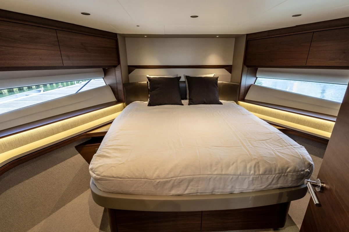 Luxurious 2025 Princess F58 yacht bedroom with elegant wood finishes and modern design.