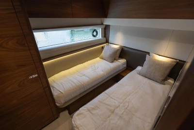 Luxurious twin cabin interior on 2025 Princess F58 yacht, featuring elegant wood finishes.