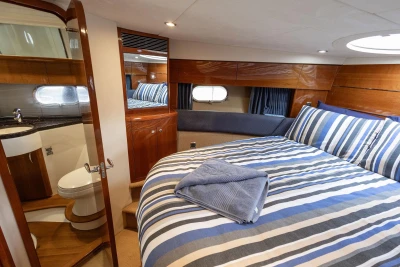 Luxurious cabin interior of 2005 Princess 42 Flybridge Motor Yacht with striped bedding.