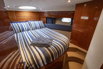 Luxurious cabin interior of 2005 Princess 42 Flybridge Motor Yacht with striped bedding.