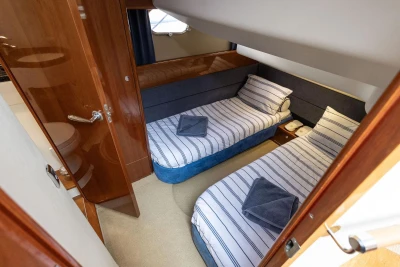 Twin cabin interior of 2005 Princess 42 Flybridge Motor Yacht with striped bedding.