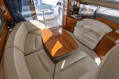 Luxurious interior of 2005 Princess 42 Flybridge Motor Yacht with leather seating and wooden table.