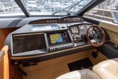 Helm of 2005 Princess 42 Flybridge Motor Yacht with navigation equipment and wooden steering wheel.