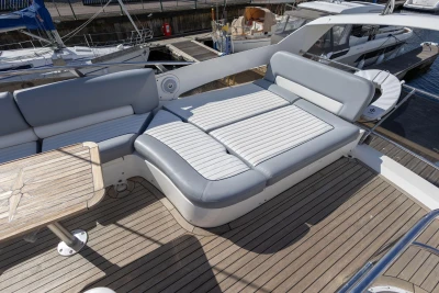 Flybridge seating area on 2005 Princess 42 Motor Yacht with wooden deck and table.