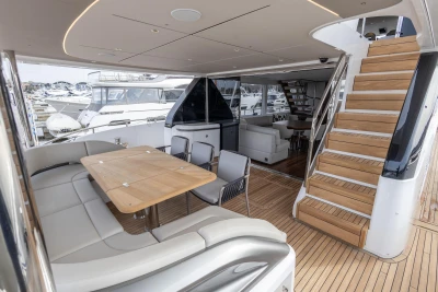 Luxurious 2023 Princess X80 yacht interior with elegant seating, dining area, and wooden staircase.