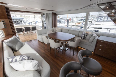 Luxurious interior of 2023 Princess X80 yacht with elegant seating and wooden flooring.