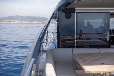 2024 Princess X80 yacht cruising on calm waters with scenic coastal backdrop.