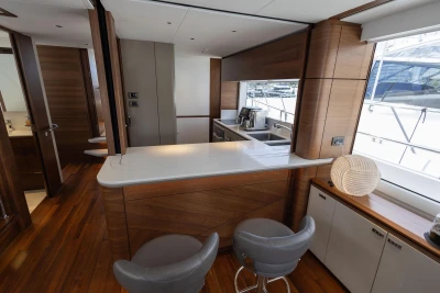 Luxurious 2024 Princess X80 yacht interior with modern kitchen and elegant wood finishes.