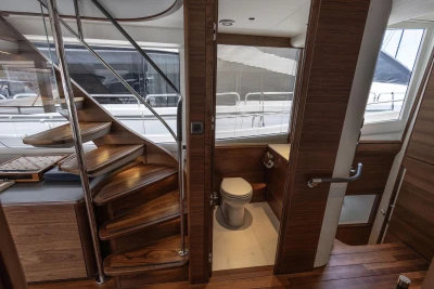 Luxurious interior of 2024 Princess X80 yacht featuring wooden staircase and modern bathroom.