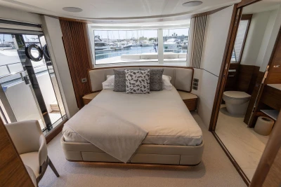Luxurious 2024 Princess X80 yacht bedroom with elegant decor and marina view.