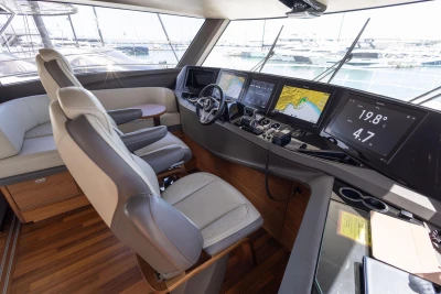 Luxurious 2024 Princess X80 yacht cockpit with advanced navigation displays and plush seating.