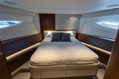Luxurious bedroom interior of 2024 Princess X80 yacht, featuring elegant wood finishes and modern design.