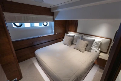Luxurious bedroom interior of 2024 Princess X80 yacht with elegant wood paneling.