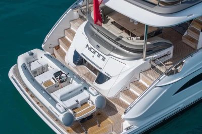 Luxury 2024 Princess X80 yacht with tender boat on turquoise water.