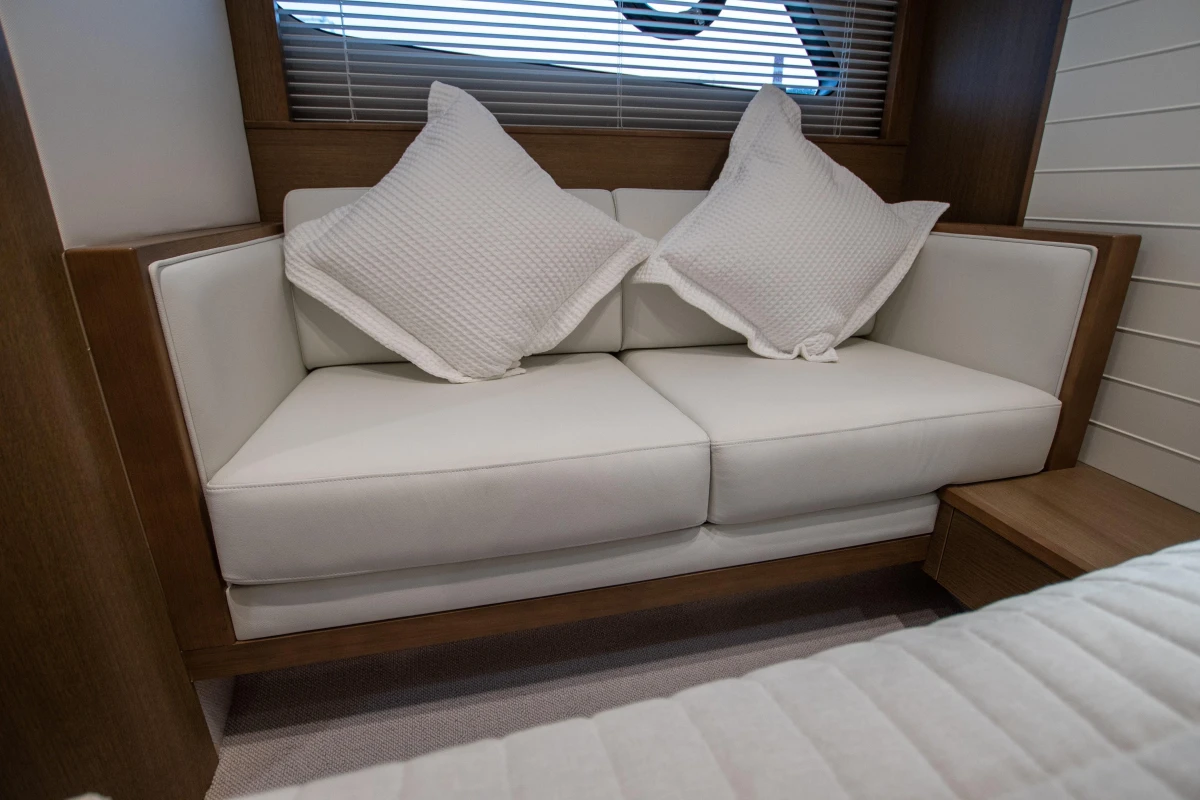 Luxurious white sofa with cushions in 2017 Princess V48 Open yacht interior.