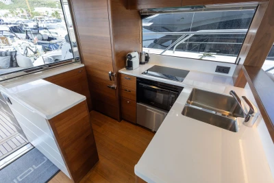 Modern kitchen interior on 2018 Princess S65 yacht with sleek wood cabinetry and appliances.