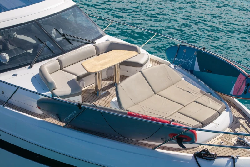 Luxurious 2018 Princess S65 yacht deck with seating and paddleboards on turquoise water.