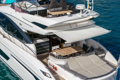 Luxurious 2018 Princess S65 yacht with spacious deck and elegant seating area on the water.
