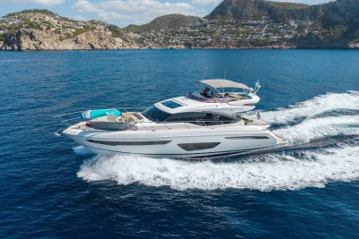 Luxurious 2018 Princess S65 yacht cruising on blue ocean near scenic coastline.