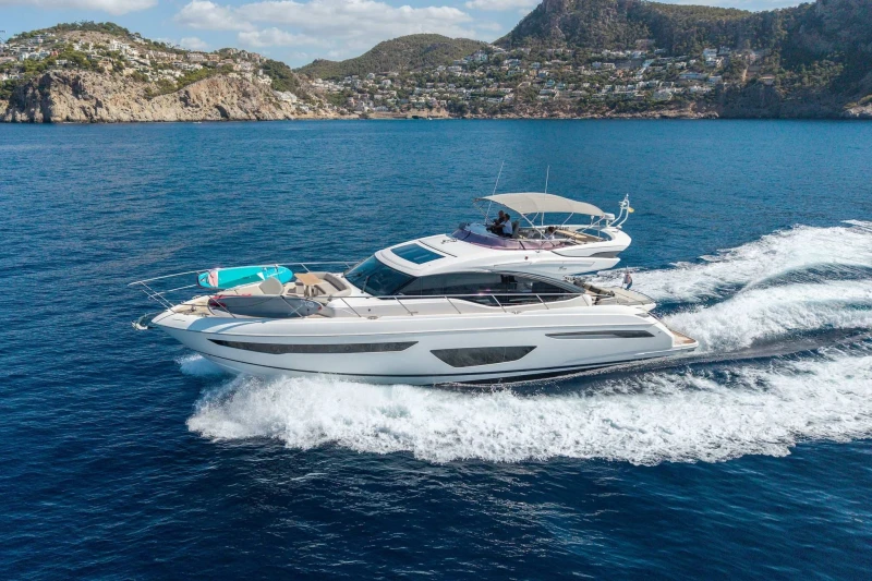 Luxurious 2018 Princess S65 yacht cruising on blue ocean near scenic coastline.