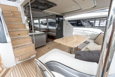 Luxurious interior of 2026 Princess Y72 yacht with wooden stairs and elegant seating area.