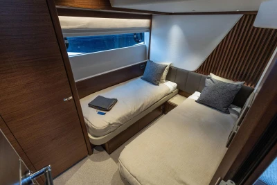 Luxurious twin cabin interior on 2026 Princess Y72 yacht, featuring modern design and cozy bedding.