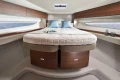 Luxurious interior of 2026 Princess V50 Open yacht with elegant bedding and wood accents.