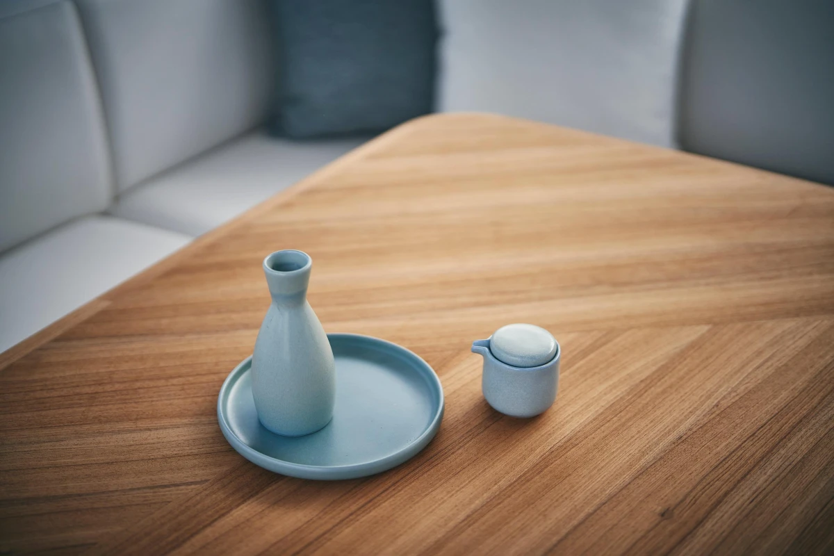 Minimalist wooden table with blue ceramic vase and cup, aboard 2026 Princess V50 Open yacht.