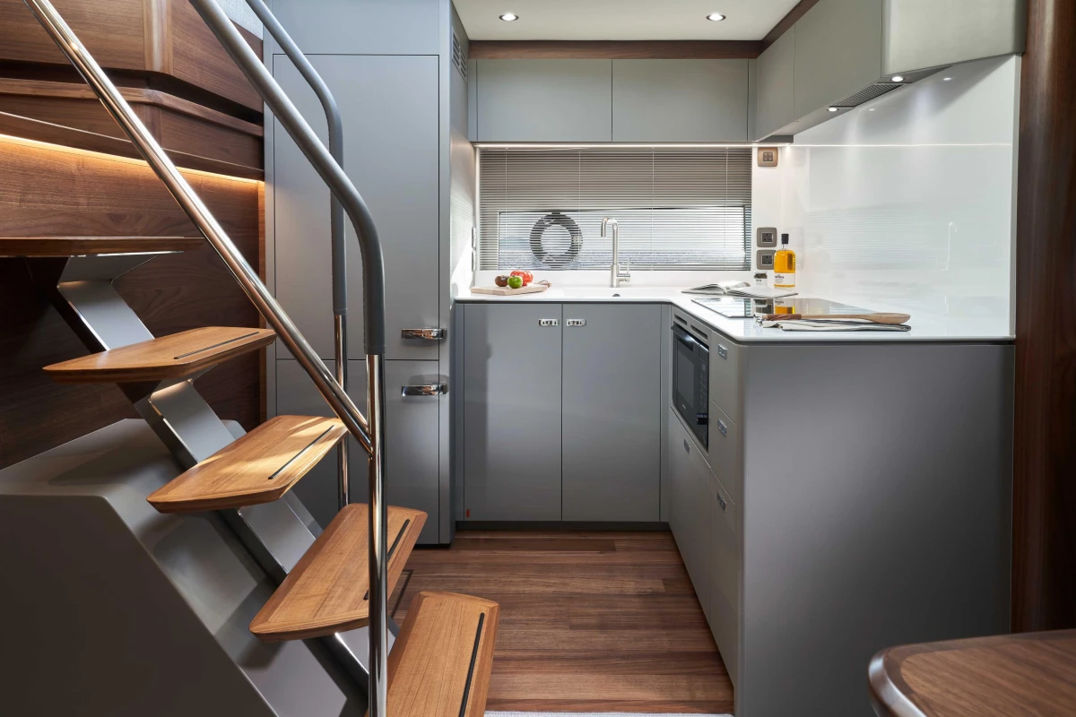 Modern kitchen interior of 2026 Princess V50 Open yacht, featuring sleek design and wooden accents.