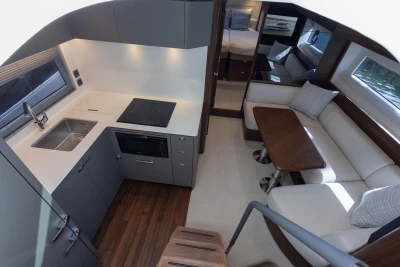 Modern interior of 2026 Princess V50 Open yacht with sleek kitchen and cozy seating area.