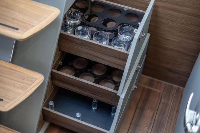 Wooden cabinet with glass holders in a 2026 Princess V50 Open yacht interior.