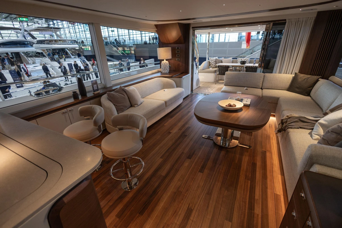 Luxurious interior of 2026 Princess X80 yacht with elegant seating and wooden flooring.