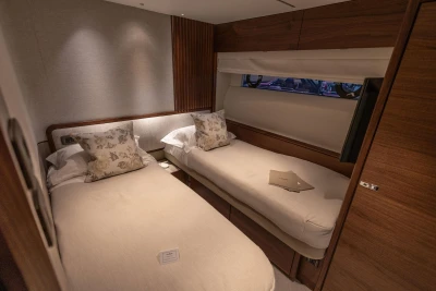 Luxurious twin cabin interior of 2026 Princess X80 yacht with elegant wood finishes.