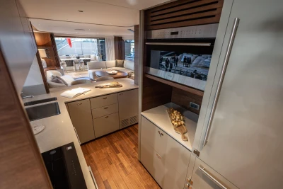 Luxurious interior of 2026 Princess X80 yacht with modern kitchen and elegant seating area.