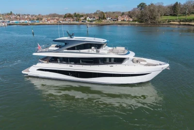 Luxurious 2026 Princess X80 yacht cruising on serene waters near a picturesque shoreline.