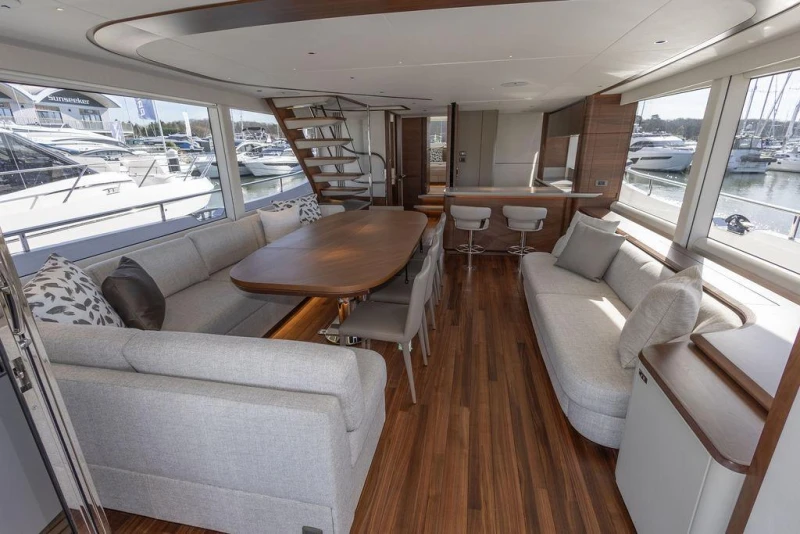 Luxurious interior of 2026 Princess X80 yacht with elegant seating and wooden flooring.