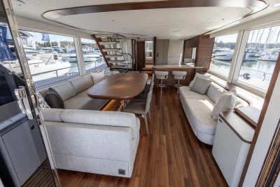 Luxurious interior of 2026 Princess X80 yacht with elegant seating and wooden flooring.