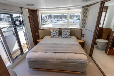 Luxurious bedroom interior of 2026 Princess X80 yacht with marina view.