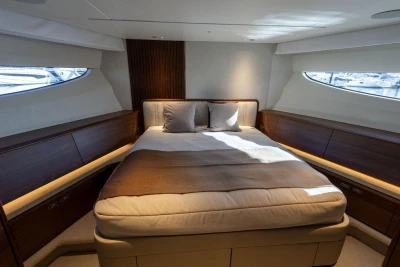 Luxurious bedroom interior of 2026 Princess X80 yacht with elegant wood accents.