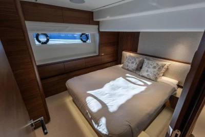 Luxurious bedroom interior of 2026 Princess X80 yacht with elegant wood finishes.