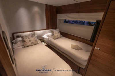 Luxurious twin cabin interior of 2026 Princess X80 yacht, featuring elegant wood finishes.