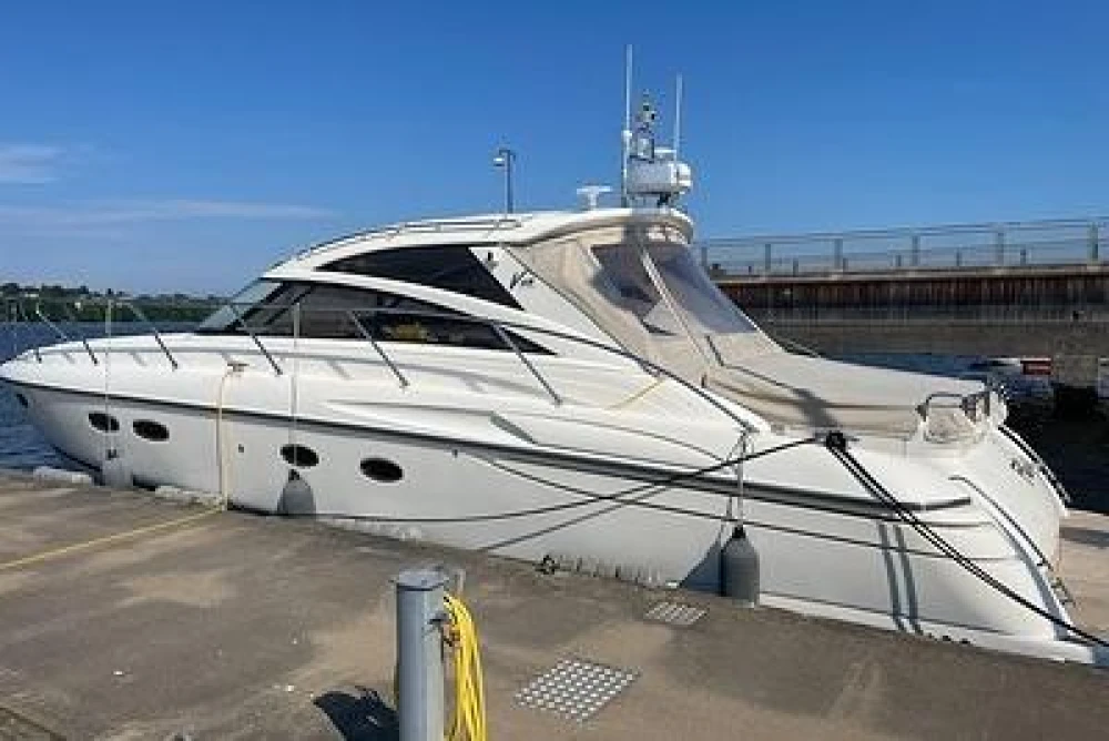 2007 Princess V48 yacht docked at a marina under clear blue skies.