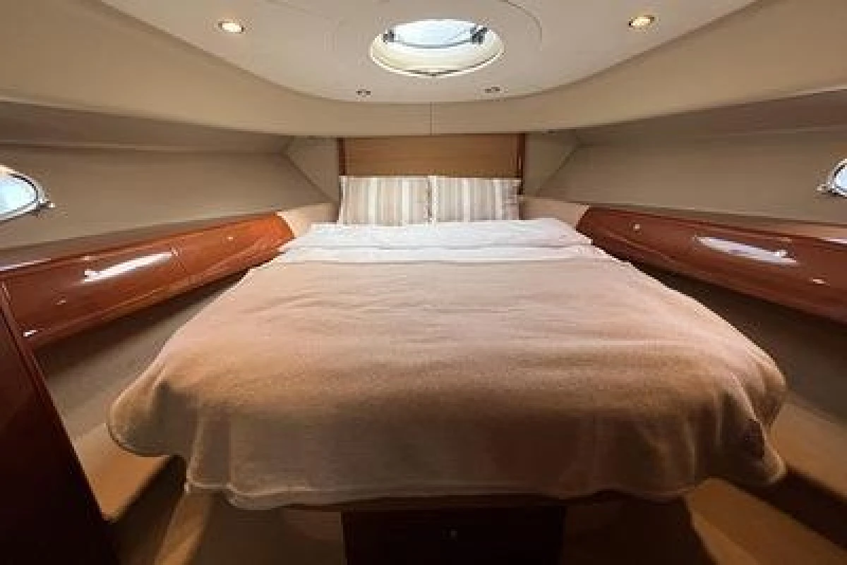 Luxurious cabin interior of a 2007 Princess V48 yacht with a cozy bed.