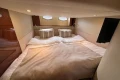 Luxurious cabin interior of 2007 Princess V48 yacht with cozy bedding and ambient lighting.