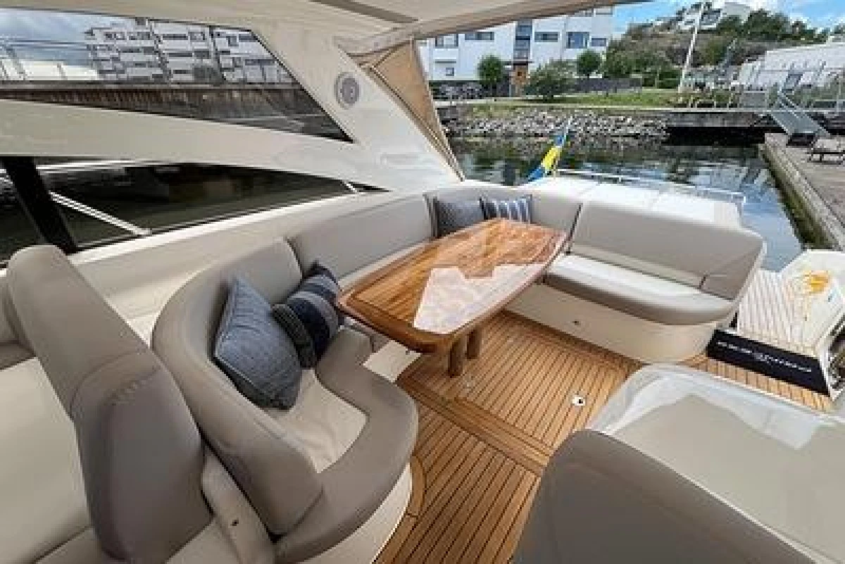 Luxurious 2007 Princess V48 yacht with elegant seating and wooden table on deck.
