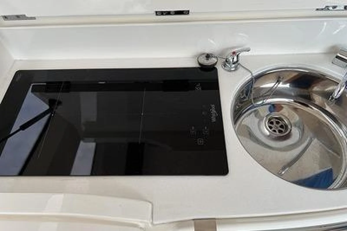 Compact kitchen area in a 2007 Princess V48 yacht with stove and sink.