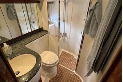 2007 Princess V48 yacht bathroom with shower, sink, and wooden flooring.